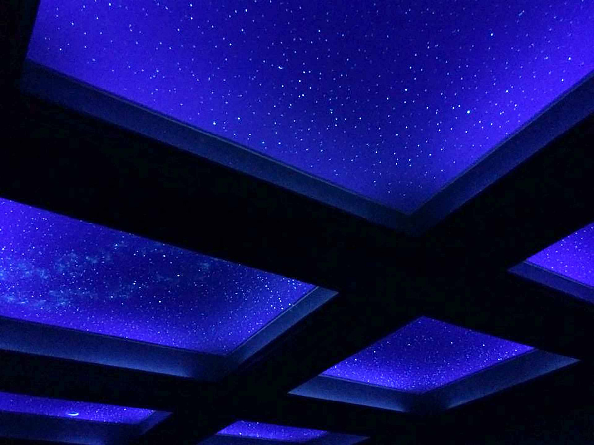 Ceiling with beams and a Night Sky Mural star ceiling with black lights on
